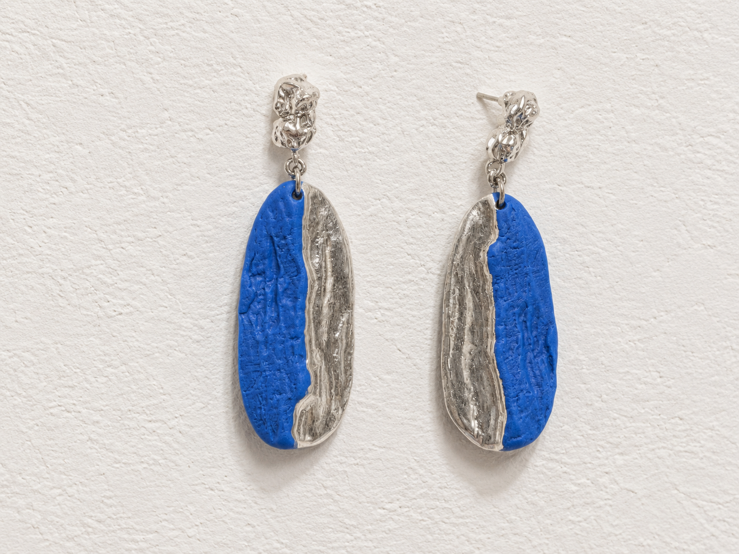 Tidal Blue handmade ceramic earrings showing ocean-blue ceramic texture and white-gold-plated detail by ZELIN ART.