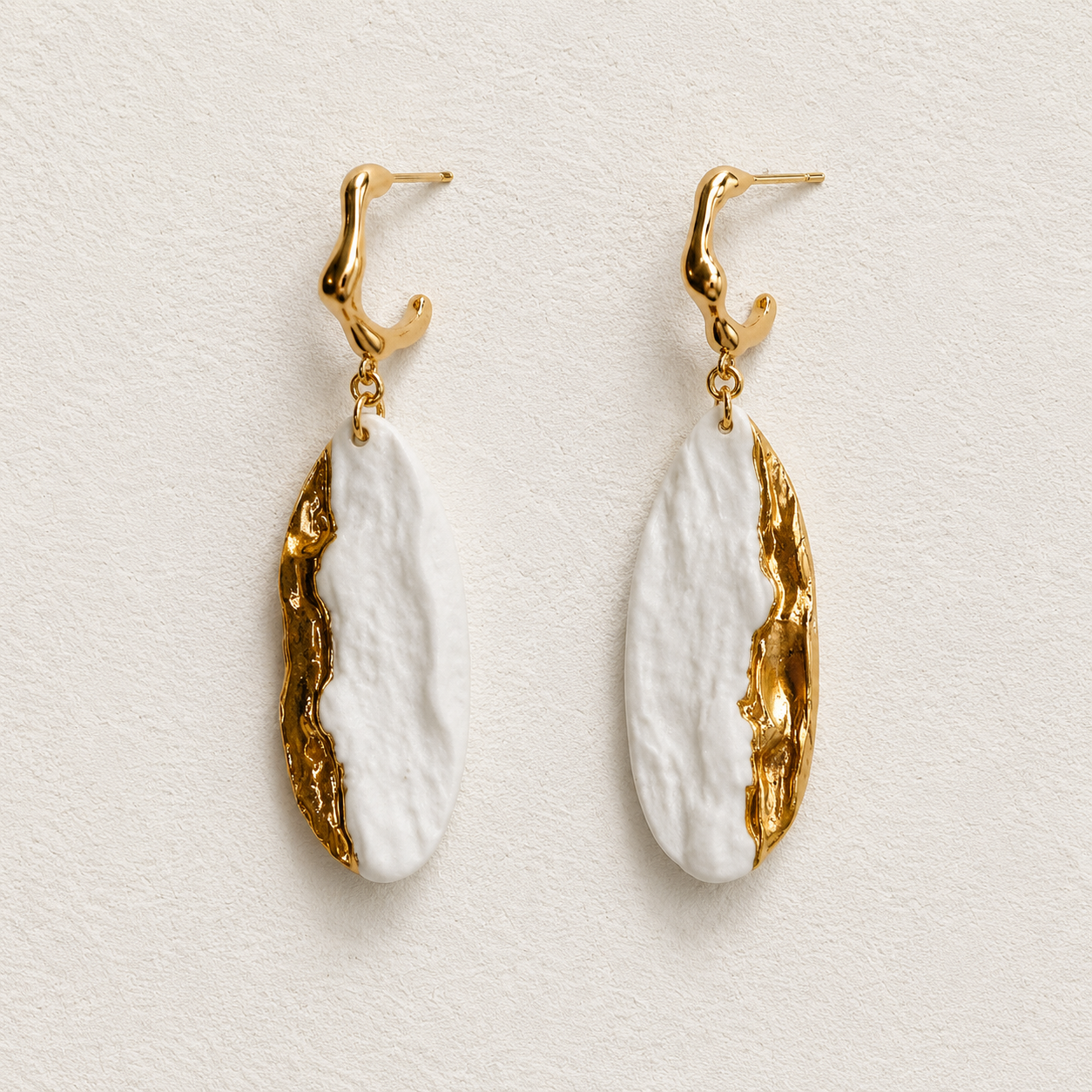 Ivory Current handmade ceramic earrings showing ivory ceramic texture and a flowing gold-plated edge by ZELIN ART.