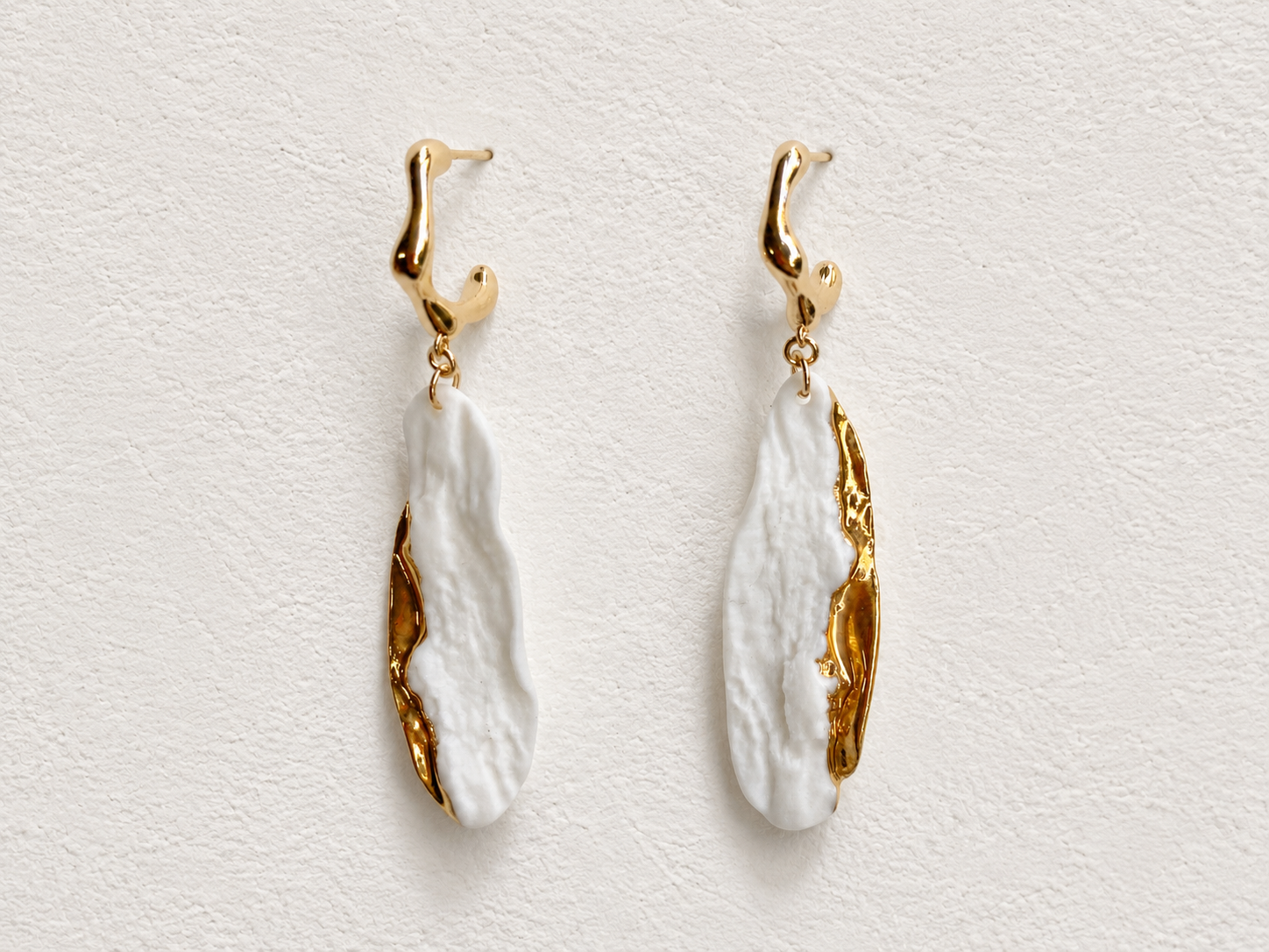 Ivory Current handmade ceramic earrings showing ivory ceramic texture and a flowing gold-plated edge by ZELIN ART.