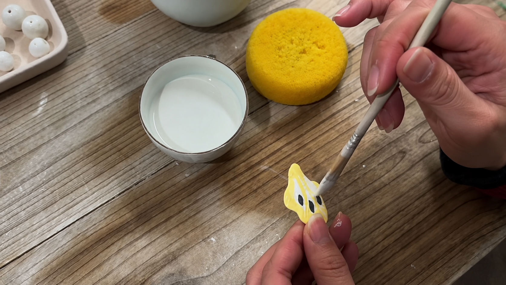 Glaze being applied to a porcelain form